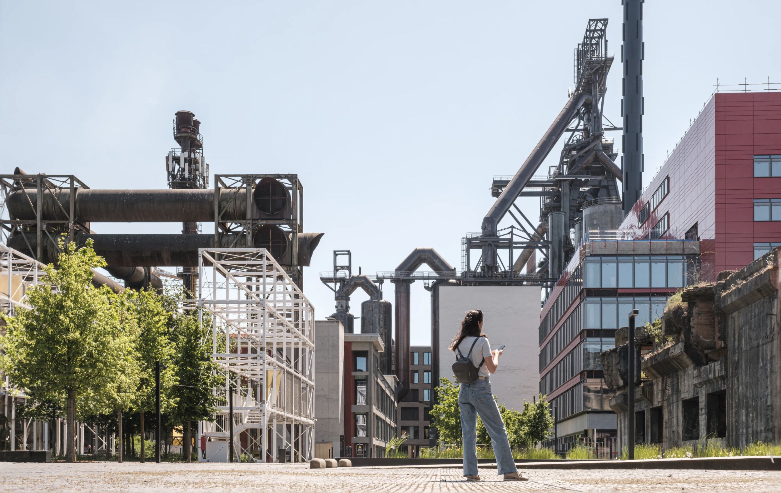 Personne se déplaçant sur le site industriel de Belval avec anciens hauts fourneaux et structures métalliques