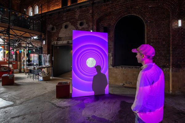 Visiteur devant une installation artistique éclairée en violet au Waassertuerm + Pomhouse à Dudelange